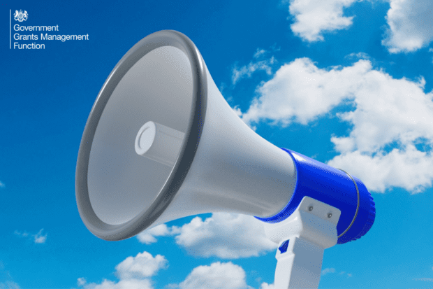 Image of a speaker in front of blue cloudy sky, suggesting an announcement
